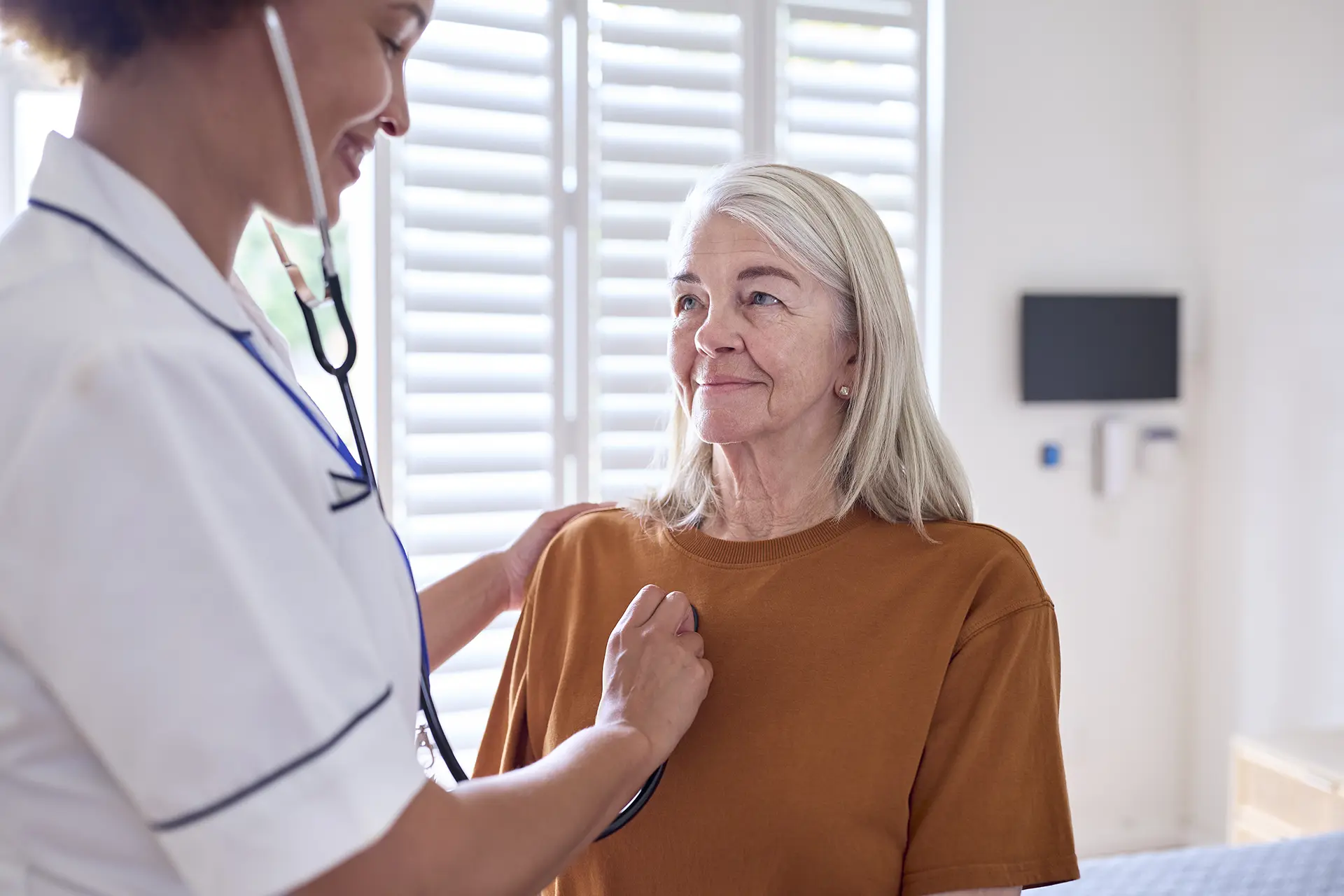 An older patient is being checked by a doctor at a primary care clinic.